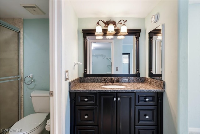 3041 Sandpiper Bay Cir Unit H201, Naples, FL 34112 - bathroom with vanity, toilet, a stall shower, and a chandelier