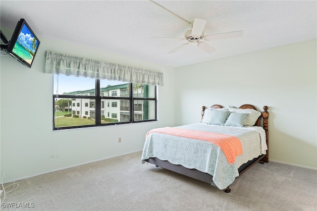 carpeted bedroom with a textured ceiling and ceiling fan