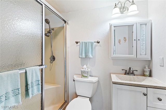 bathroom featuring a shower with door, vanity, and toilet