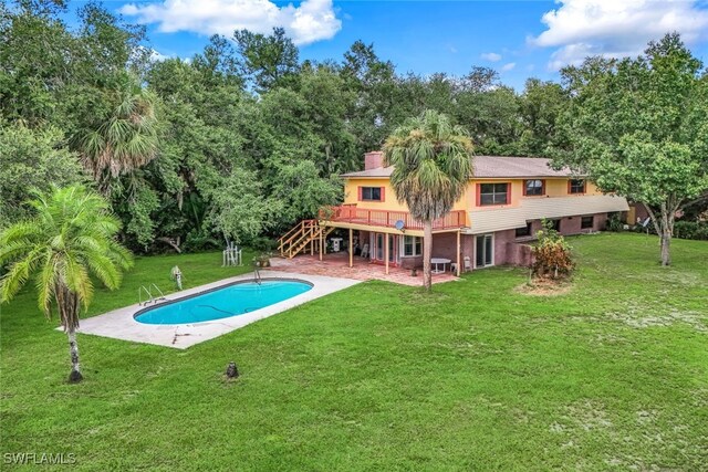 view of swimming pool with a wooden deck, a patio area, and a lawn