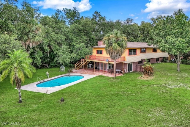 pool with a patio, stairway, a yard, and a wooden deck