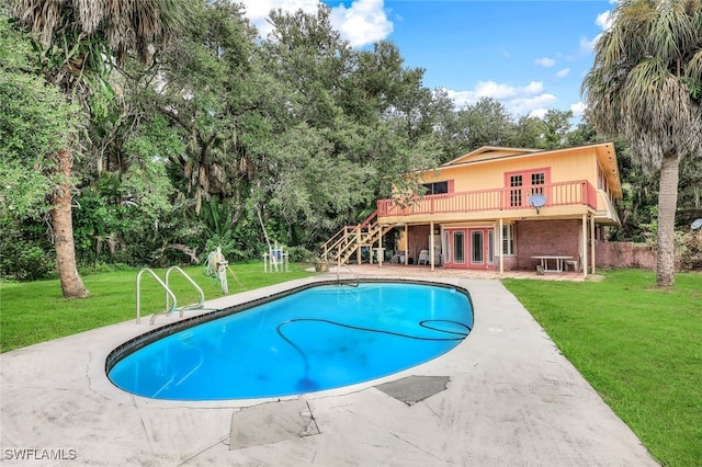 18191 Slater Rd, North Fort Myers, FL 33917 - outdoor pool with stairway, a wooden deck, a lawn, and french doors