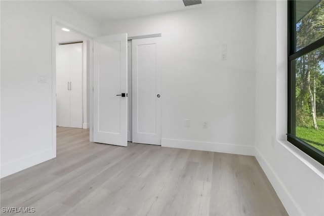 spare room featuring light hardwood / wood-style floors and a wealth of natural light