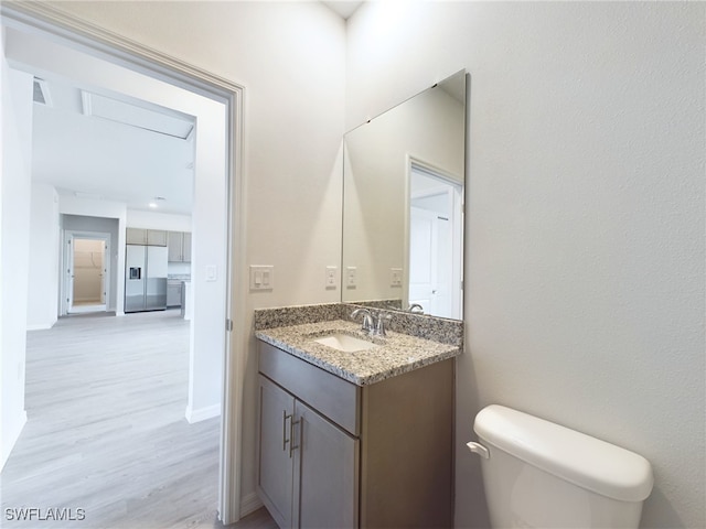 bathroom with vanity, toilet, and hardwood / wood-style flooring