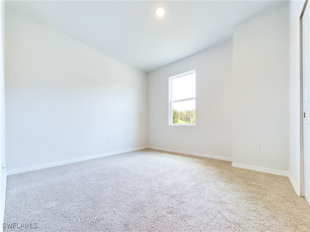 spare room featuring light colored carpet