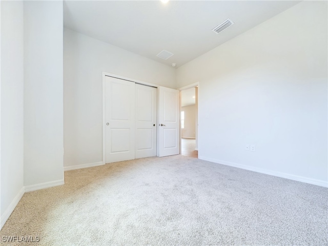 unfurnished bedroom featuring carpet flooring and a closet