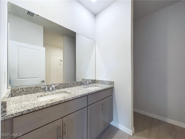 bathroom with hardwood / wood-style flooring and double sink vanity