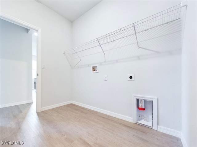 clothes washing area with light wood-type flooring, hookup for an electric dryer, and washer hookup