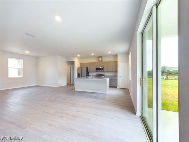 unfurnished living room featuring sink and light hardwood / wood-style floors