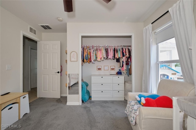 carpeted bedroom featuring ceiling fan and a closet