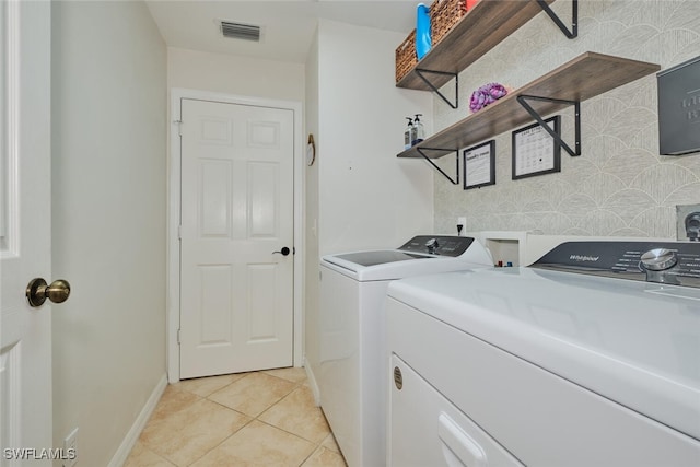 laundry area with separate washer and dryer and light tile patterned flooring