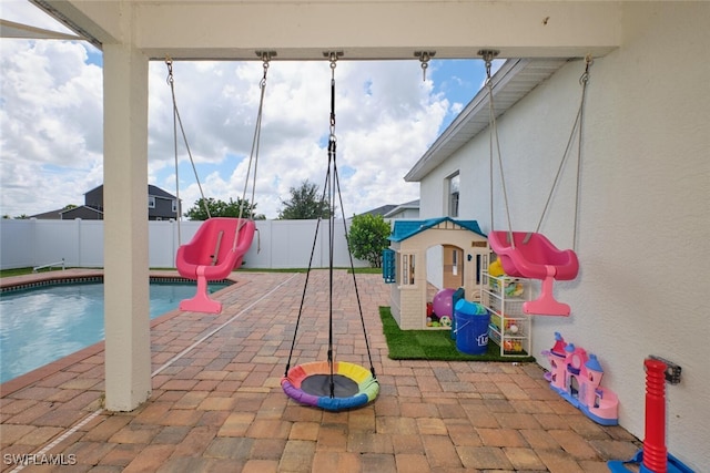 view of playground with a patio, a fenced backyard, and a fenced in pool