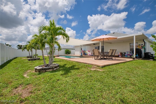 rear view of house with a fenced backyard, a lawn, and a patio