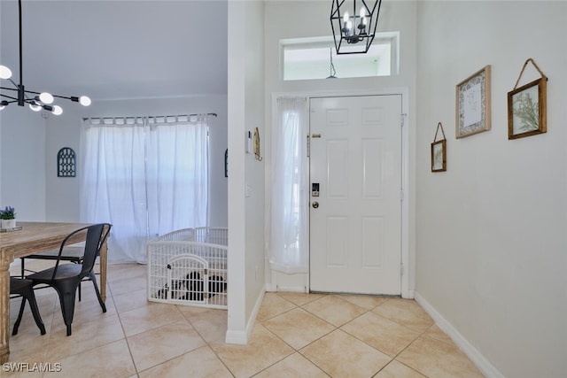 entrance foyer featuring a healthy amount of sunlight, a notable chandelier, and light tile patterned floors