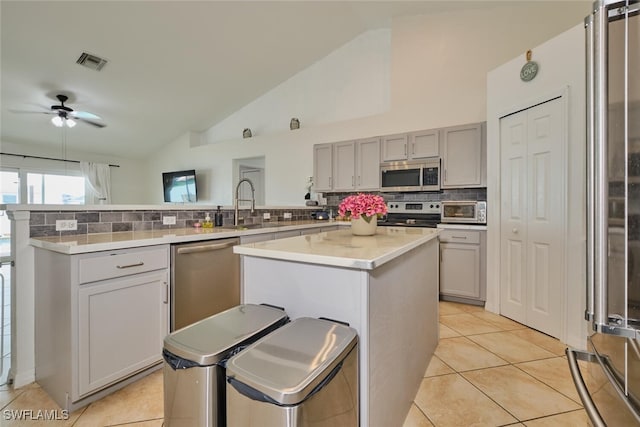 kitchen featuring appliances with stainless steel finishes, a center island, and lofted ceiling