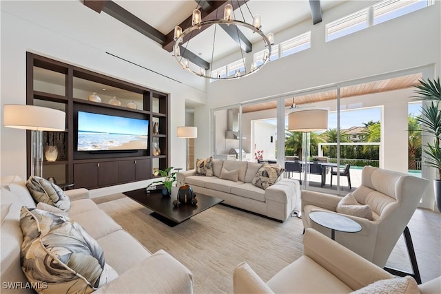 living area with a high ceiling, light tile patterned flooring, built in features, and an inviting chandelier