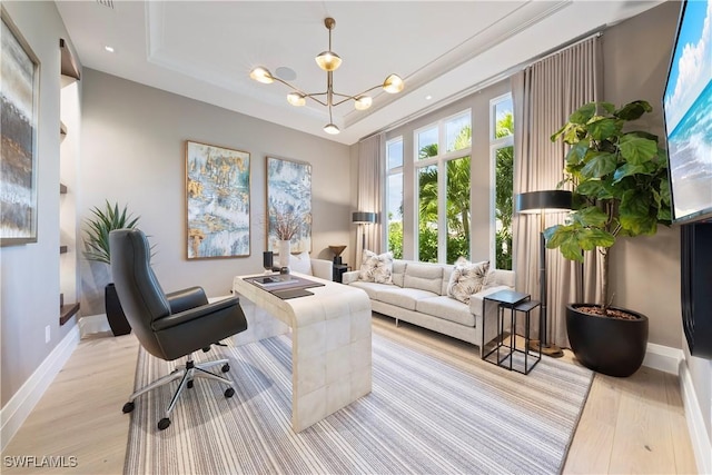 office with light wood-type flooring, a raised ceiling, an inviting chandelier, and baseboards