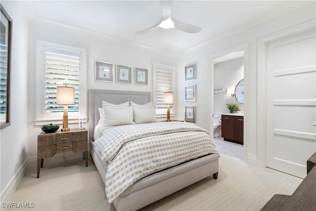 bedroom with ceiling fan, ornamental molding, ensuite bath, and baseboards