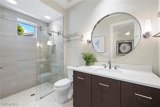 bathroom with a shower stall, vanity, and toilet