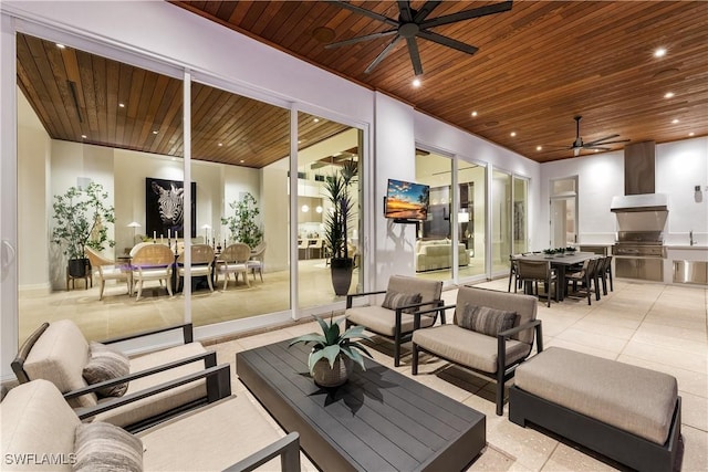 view of patio with exterior kitchen, outdoor dining area, an outdoor living space, and a ceiling fan