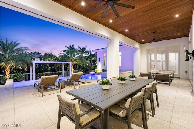 4220 Crayton Rd, Naples, FL 34103 - patio terrace at dusk with a ceiling fan, a patio area, an outdoor pool, and outdoor dining area