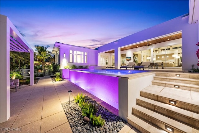 4220 Crayton Rd, Naples, FL 34103 - pool at dusk with a patio, a ceiling fan, a hot tub, and an outdoor pool