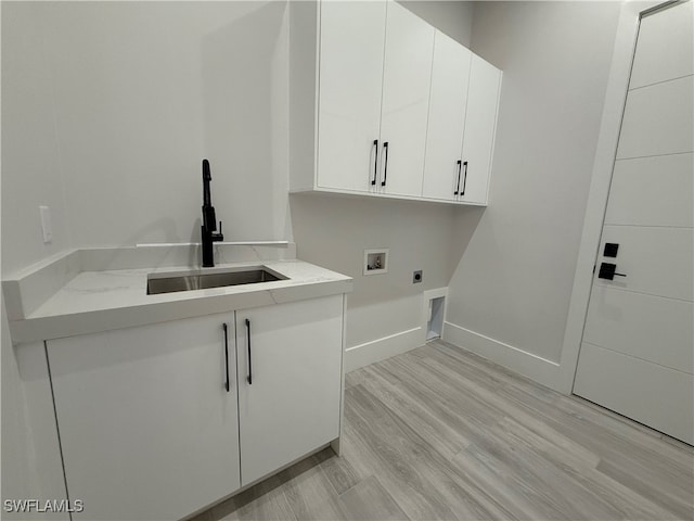 laundry room with cabinets, hookup for a washing machine, hookup for an electric dryer, sink, and light hardwood / wood-style floors