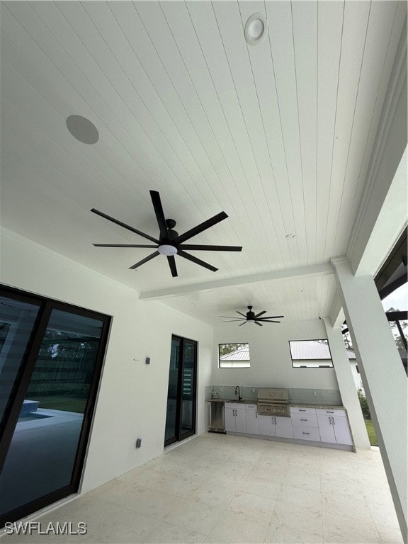 unfurnished living room featuring sink, ceiling fan, and wood ceiling