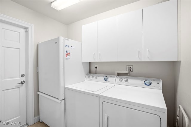 clothes washing area featuring washer and dryer and cabinets