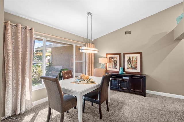 dining space with light carpet and lofted ceiling