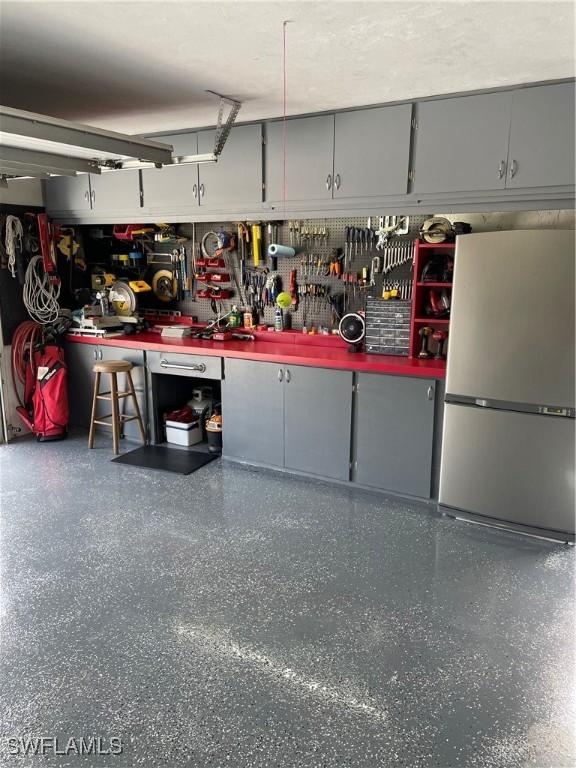 garage featuring a workshop area and stainless steel fridge