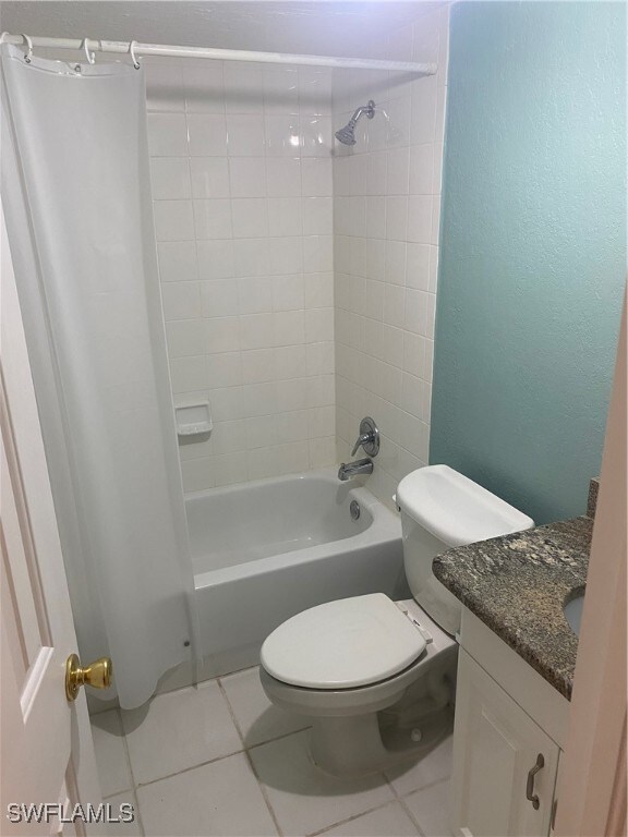 full bathroom with tile patterned flooring, vanity, toilet, and tiled shower / bath