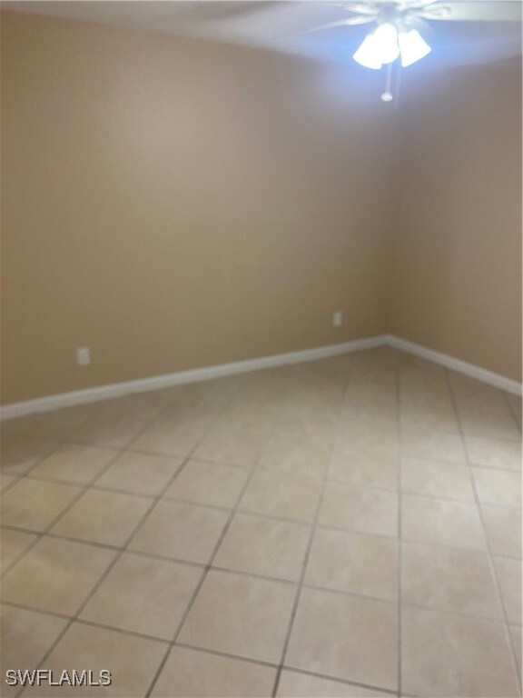 unfurnished room with light tile patterned floors and ceiling fan