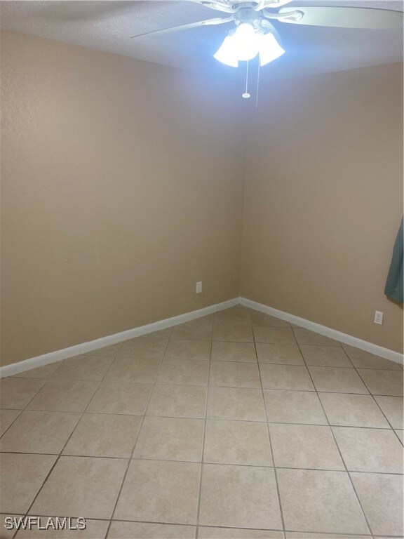 spare room featuring ceiling fan and light tile patterned flooring