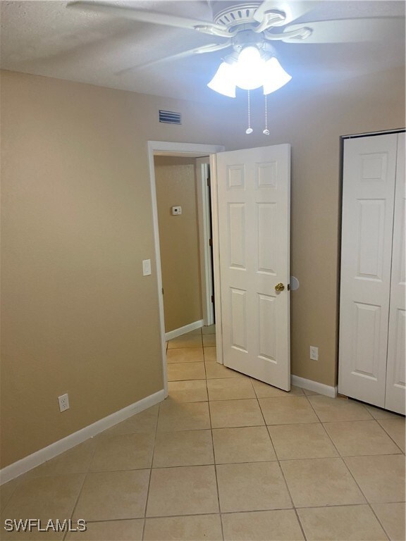 unfurnished bedroom with ceiling fan and light tile patterned floors