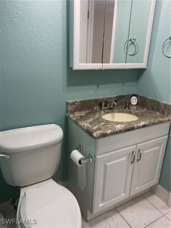 bathroom with vanity, toilet, and tile patterned floors