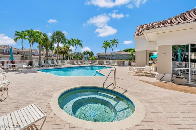 view of pool with a community hot tub and a patio