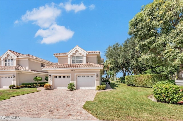 mediterranean / spanish-style home featuring an attached garage, a tile roof, decorative driveway, stucco siding, and a front yard