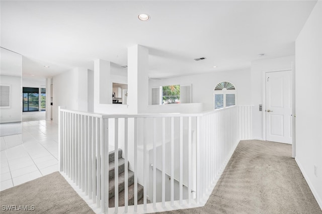 hall with visible vents, tile patterned floors, carpet flooring, an upstairs landing, and recessed lighting