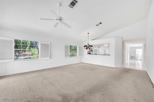 unfurnished living room featuring ceiling fan with notable chandelier, high vaulted ceiling, and light colored carpet