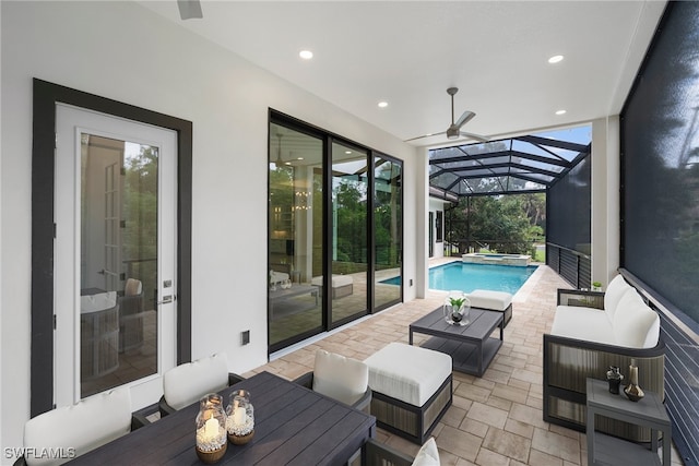 exterior space with a patio area, ceiling fan, glass enclosure, and outdoor lounge area