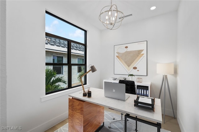 office featuring light wood-type flooring, a wealth of natural light, and an inviting chandelier