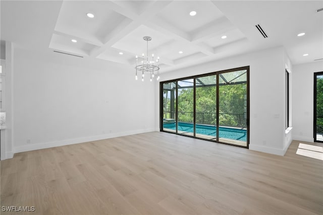 spare room with coffered ceiling, light hardwood / wood-style flooring, and beam ceiling