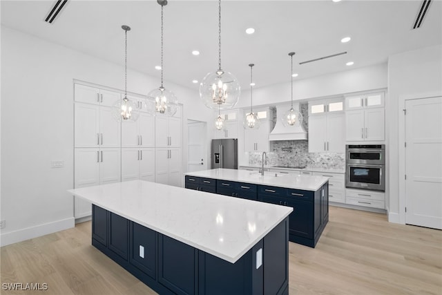 kitchen featuring a large island, custom exhaust hood, stainless steel appliances, tasteful backsplash, and blue cabinets