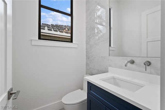 bathroom featuring vanity, toilet, and tile walls