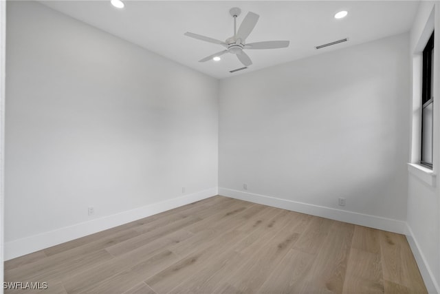 spare room with light wood-style flooring, visible vents, and baseboards