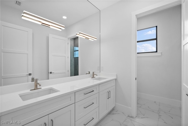 bathroom with a sink, visible vents, baseboards, marble finish floor, and double vanity