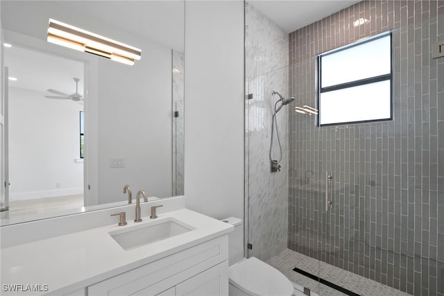 bathroom with vanity, toilet, an enclosed shower, and ceiling fan