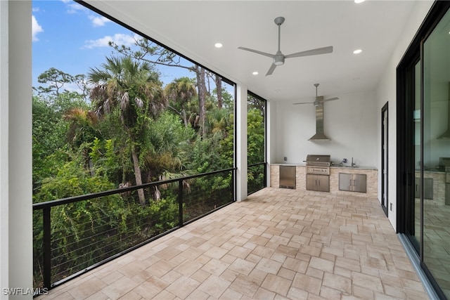 unfurnished sunroom with ceiling fan and sink