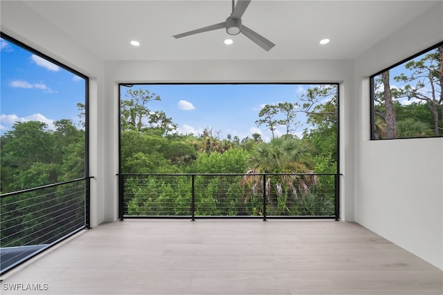 unfurnished sunroom with a wealth of natural light and ceiling fan